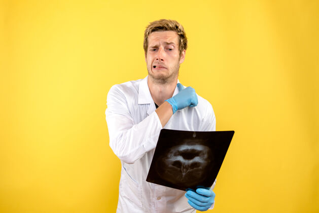 看正面图黄色背景上手持x光片的男医生医疗外科卫生科维德-男性帅哥专业人士