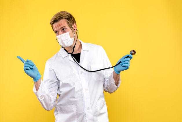 男性正面图黄色背景上戴口罩的男医生大流行健康病毒肖像人实验室