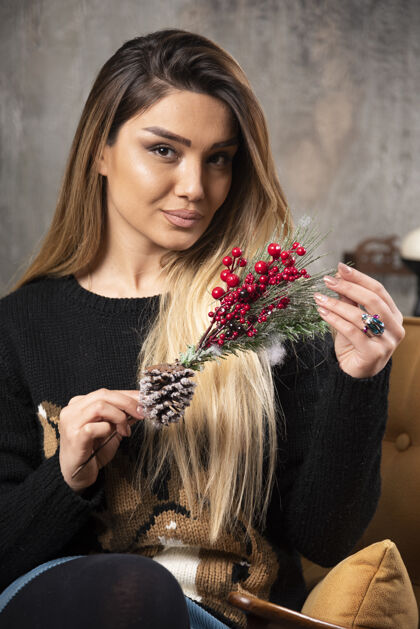 人年轻女子手持圣诞冬青树枝的肖像高品质照片年轻女孩肖像