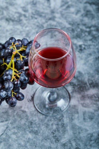 饮料一杯红酒加葡萄放在大理石上顶视图活动酒杯