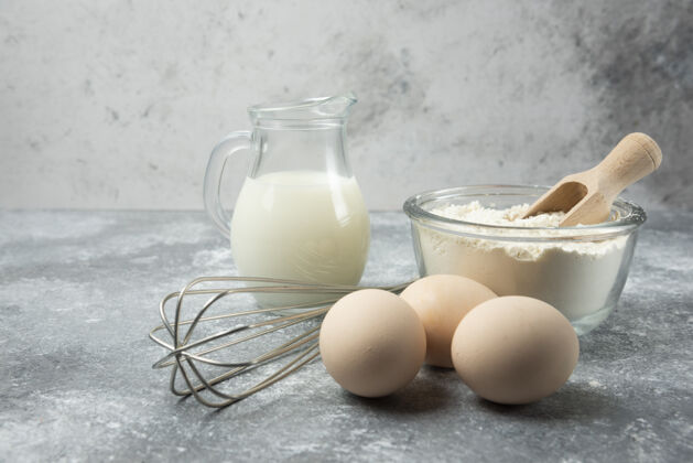 牛奶面粉 鸡蛋 牛奶和胡须放在大理石桌上鸡蛋做的厨具