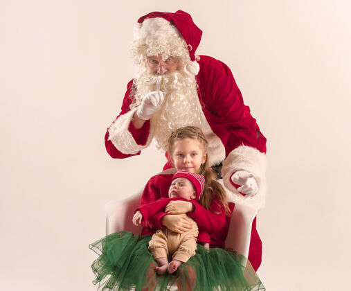 睡觉可爱的新生小女婴和漂亮的妹妹穿着圣诞服装和圣诞老人的服装和帽子的男子圣诞画像房子肖像可爱