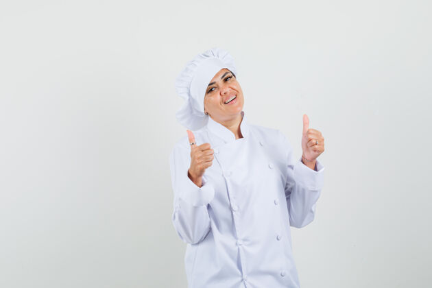 工作女厨师穿着白色制服竖起大拇指 看起来很自信柜台厨师工作