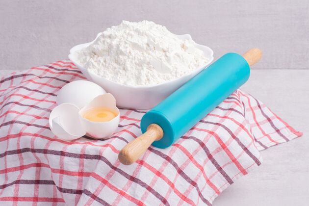 煮碎鸡蛋 擀面杖和一碗面粉放在桌布上软滚烹饪