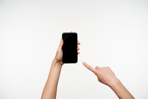 黑色年轻女子的手被举起的肖像 同时保持智能手机 并显示在屏幕上与食指 隔离在白色语言电话女性