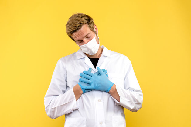 服装正面图黄色背景上的男医生累了大流行的医疗保健病毒成人医生专业