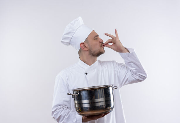 厨师年轻英俊的厨师身着厨师制服 拿着锅炉 在与世隔绝的空白处做着可口的手势手势制服空间