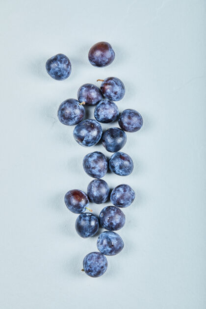 浆果一组新鲜的李子放在蓝色的上面顶部农业视图
