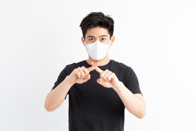 生病停止civid-19 亚洲男子戴口罩显示停止手势 停止电晕病毒爆发男性护理亚洲人