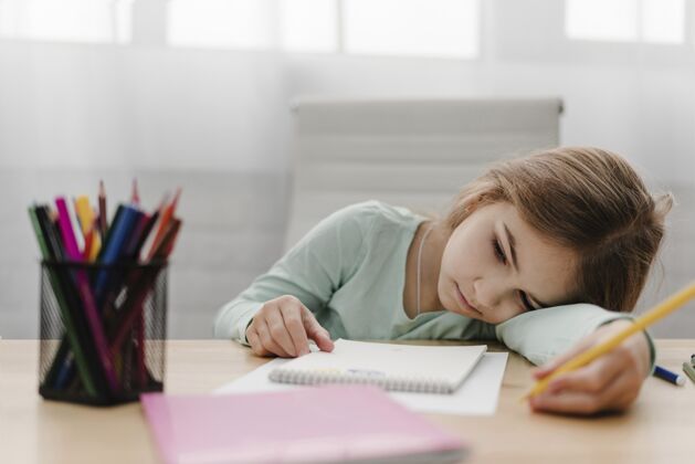 住宿无聊的小女孩在网上上课时记笔记压力室内流行病