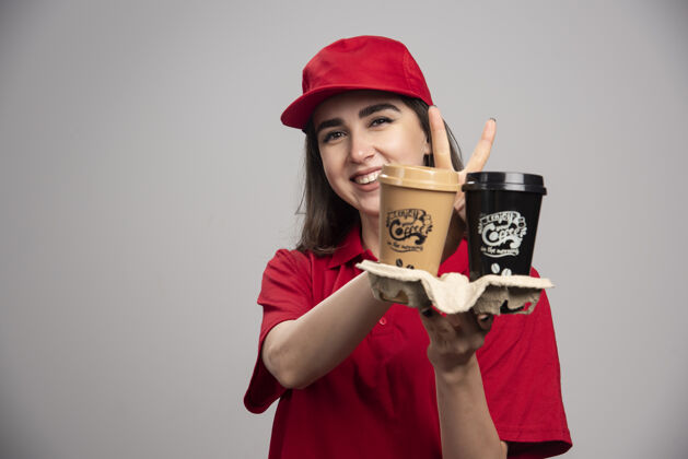 女人穿着红色制服拿着咖啡杯的女送货员人员工女性