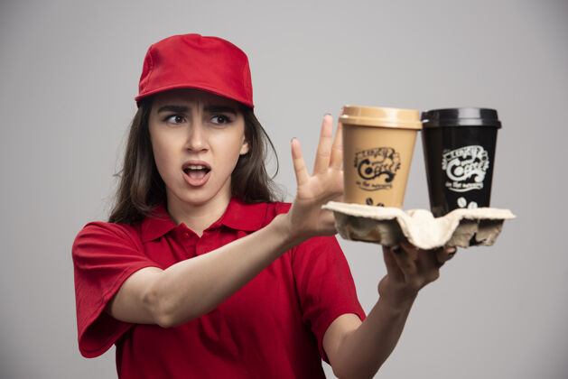 饮料穿着红色制服拿着咖啡杯的女送货员女性女人咖啡