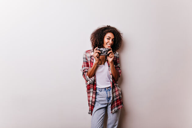 美国吸引人的棕色头发的女人站着相机微笑的非洲女摄影师被隔离在白色非洲快乐欢乐