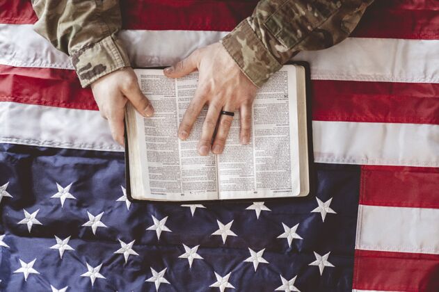 国家美国士兵手持圣经和美国国旗哀悼和祈祷部队军队超级英雄