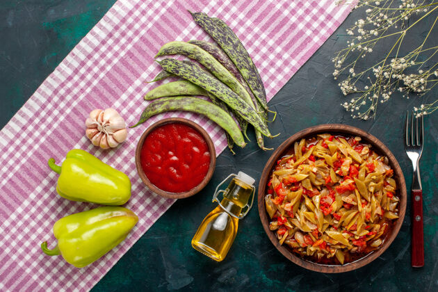 切片俯视切片蔬菜餐美味豆子餐与橄榄油蓝色背景美味蔬菜一餐