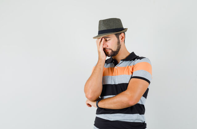 衬衫年轻人穿着t恤 戴着帽子站在思考的姿势 看上去很疲惫自信帽子男人
