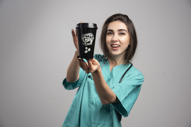 饮料女医生拿着听诊器拿着咖啡工作微笑肖像