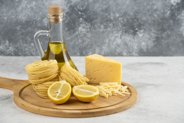 奶酪意大利面巢 油 柠檬奶酪在木板上木制柠檬食品