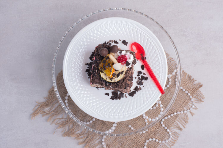 可可把一片巧克力蛋糕放在白色的盘子里 上面有珍珠视野甜点切片