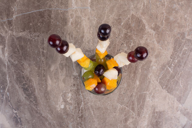 条在大理石桌上的玻璃混合水果棒切食用葡萄