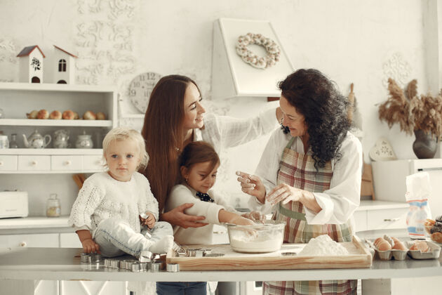 一起厨房里的人一家人准备蛋糕带着女儿和孙子的成年妇女家庭烘焙成熟
