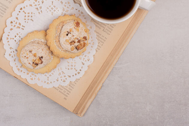顶部打开书本上的燕麦片饼干和一杯茶甜点吃的葡萄干