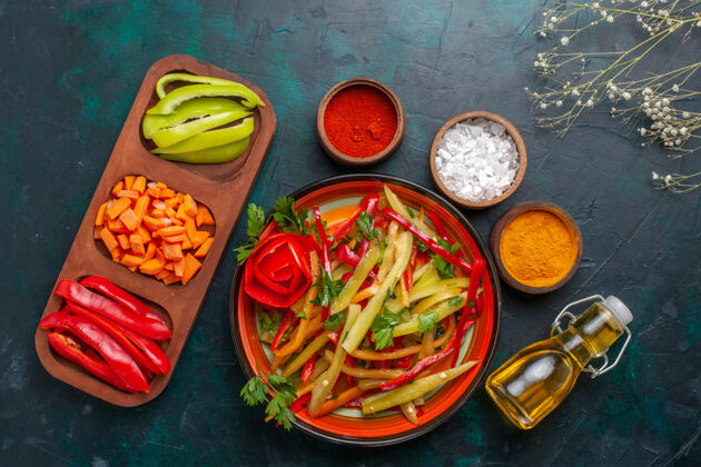 辣椒顶视图切碎的甜椒和调味品沙拉和油在深蓝色的背景上辣椒辣椒盘子