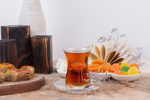 花一杯茶 各种糖果和杏干放在大理石桌上杯子茶传统