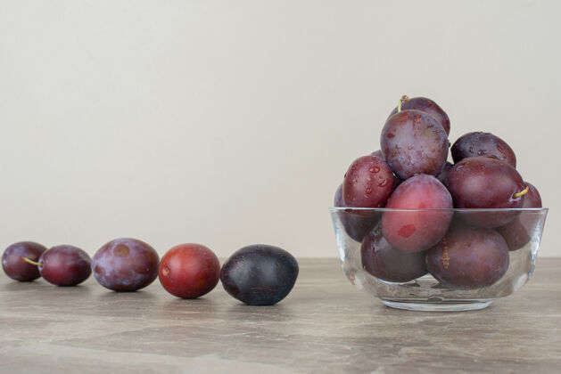 水果一碗新鲜的李子放在大理石桌上有机吃李子