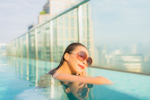 游泳池肖像美丽的亚洲年轻女子在酒店度假区的室外游泳池周围放松休闲旅游度假休闲夏天健康