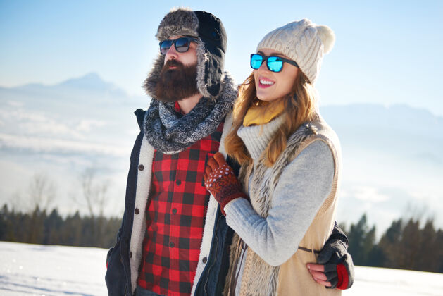 滑雪假日在雪中行走的情侣探索离开牙牙