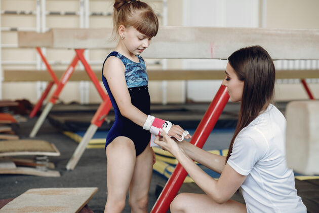 体操运动员指导学生女体操运动员 进行各种体操练习和跳跃儿童和体育 健康的生活方式儿童小儿童