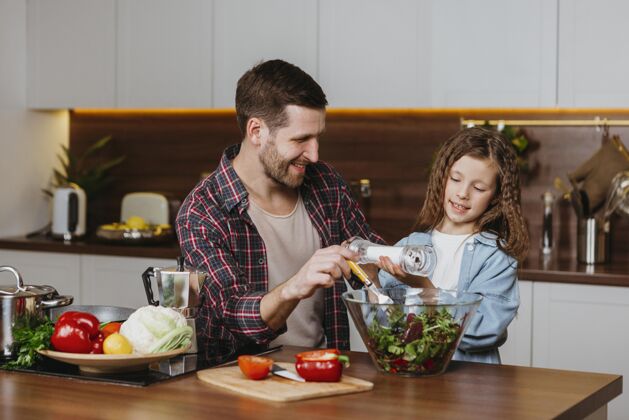 人笑脸爸爸和女儿在厨房准备食物的正面图家庭蔬菜女儿