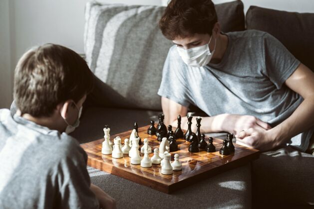 隔离被隔离时在家下棋的男孩们冠状病毒流感护理