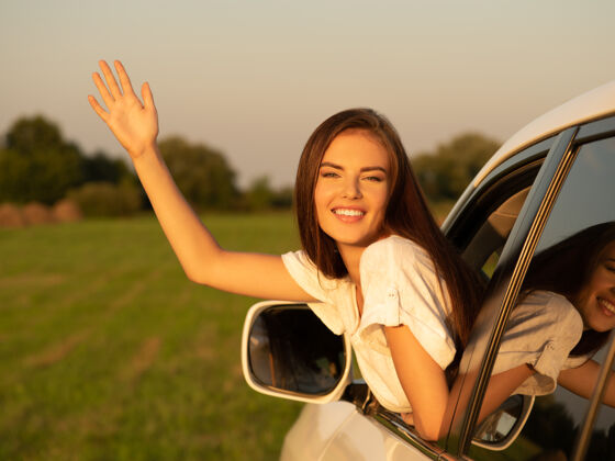 司机快乐的女人在车里举手向上女性旅行
