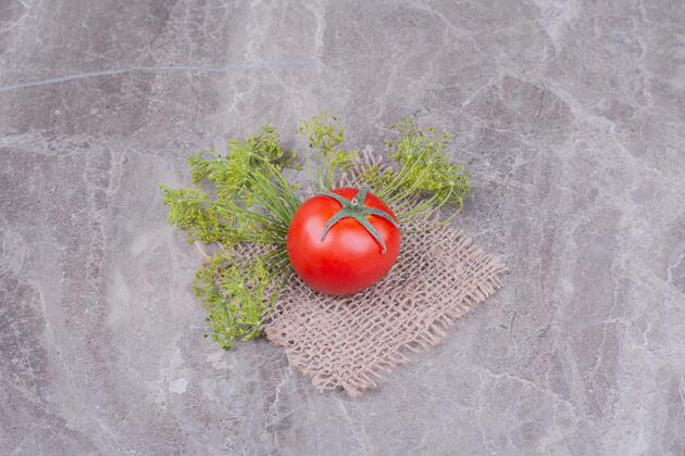 大理石一片粗麻布上有香草的红色番茄美味产品清淡