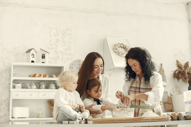 准备厨房里的人一家人准备蛋糕带着女儿和孙子的成年妇女小厨房父母