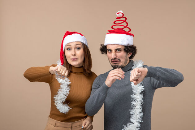 节日新年气氛喜庆的概念与兴奋酷满意可爱的情侣戴着红色圣诞老人的帽子圣诞节手势圣诞老人