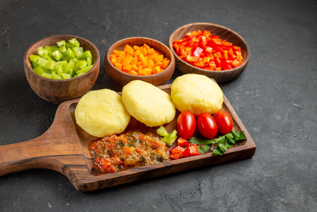 板切菜板上的生蔬菜和黑色的切碎食物的特写镜头食物一餐胡椒粉