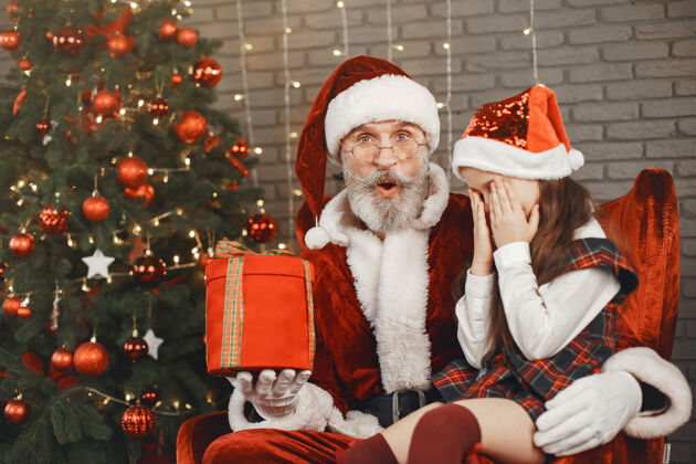 庆祝圣诞节 孩子和礼物圣诞老人给孩子带来礼物快乐的小女孩拥抱圣诞老人孩子圣诞老人拥抱