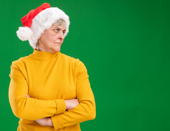 看被冒犯的戴着圣诞帽的老妇人交叉双臂站在一旁看着老人交叉手臂