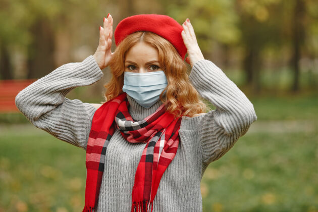 防护秋天森林里的女人戴面具的人冠状病毒主题戴红领巾的女人成人预防肖像