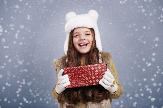 乐趣带着圣诞礼物的可爱女孩给予惊喜圣诞节