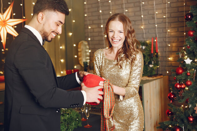 夫妇穿圣诞老人服装的人穿黑色西装的男人穿红色盒子的女人女性聚会一起