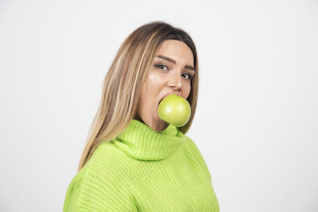 食物穿着绿色t恤的年轻女子正在吃苹果表情女人苹果