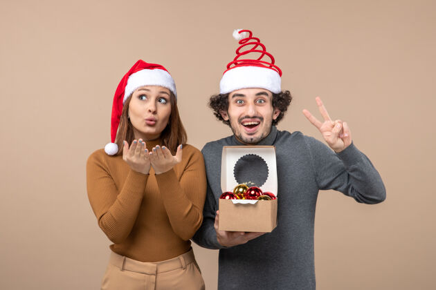 圣诞老人喜庆的心情与兴奋可爱的酷夫妇戴着红色圣诞老人的帽子圣诞节小组兴奋