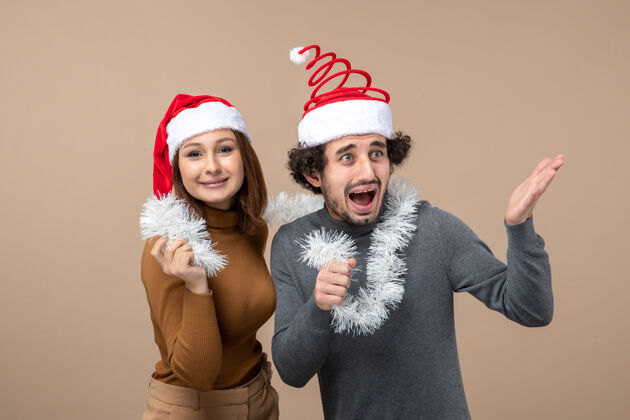 节日新年气氛喜庆的概念与兴奋酷情侣可爱的情侣戴着灰色的红色圣诞老人帽肖像成人可爱