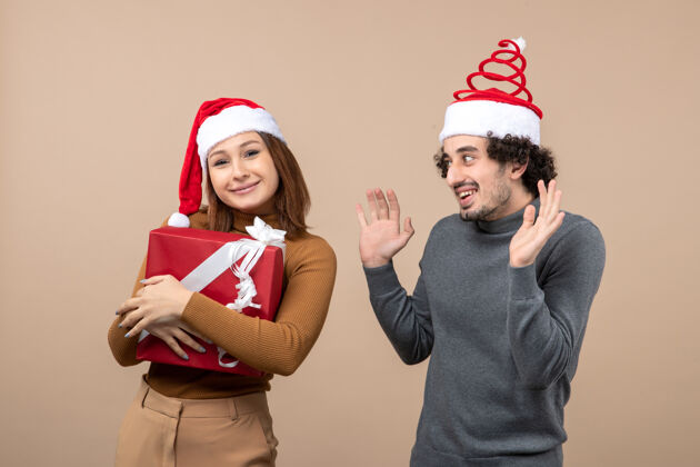 快乐新年气氛喜庆的概念与有趣可爱的夫妇戴着红色圣诞老人帽的灰色镜头男心情节日