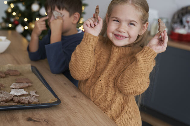儿童可爱的女孩展示自制姜饼饼干节日圣诞树展示