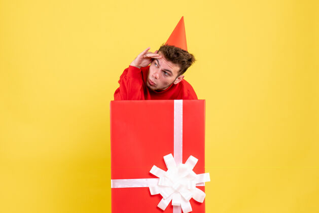 年轻正面图：礼品盒内穿红色衬衫的年轻男性节日年份颜色